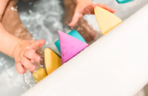 baby playing with blockaroo in bath tub