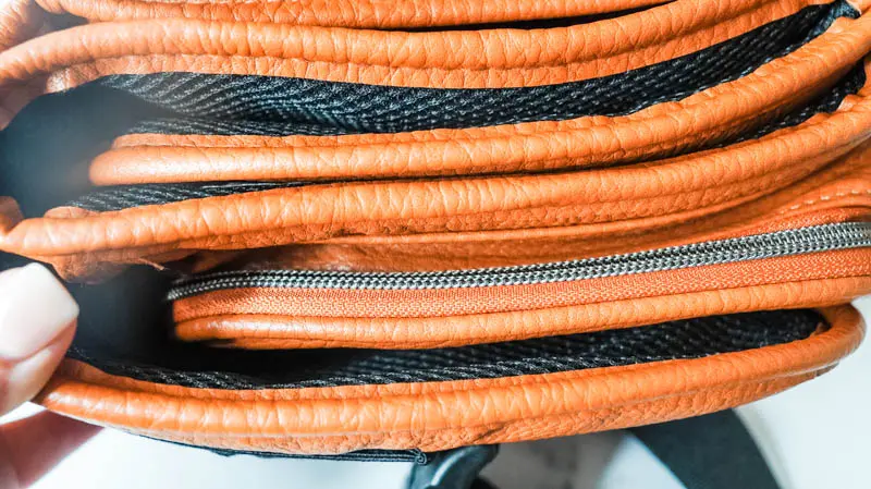 close up of the zippers and pockets on the tushbaby