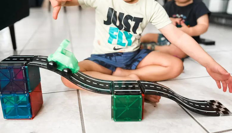 little-boy-playing-with-Magna-Tiles-car-set