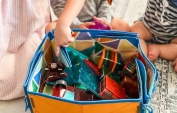 three kids playing with magnatiles in a storage bin